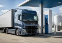 Envisioning Hydrogen Refuelling Infrastructure for Heavy-Duty Transport Blue semi-truck refueling at a pump at an industrial fueling station with storage tanks in the background?